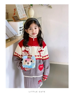 Close-up of plush bear bag with pearl handle and knit cardigan with bow bear embroidery