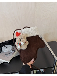 Detail of glove-shaped crossbody bag in coffee suede with cute plush bear charm
