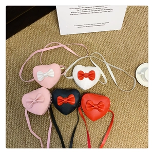 Detailed display of heart-shaped kids crossbody bags in four colors with bow accents