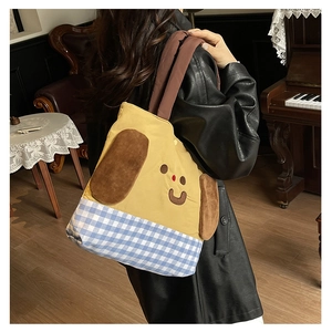 Detail of cute yellow canvas kid crossbody bag with cartoon dog ears and plaid base