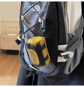 Gelbe Mini-Taktik-Schlüsseltasche mit Metallreißverschluss und Karabiner am Rucksack