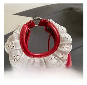 Close-up of red polka dot mini bag featuring lace handle and silver metal rings