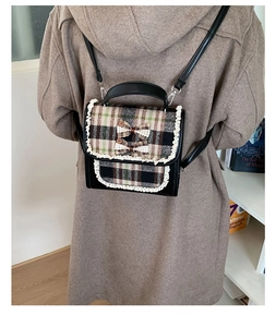 Detailed view of checkered mini backpack with lace edges and bows on a child model