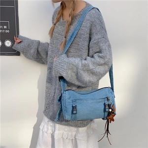 Sac bandoulière en denim bleu rétro avec pendentif étoile porté par un mannequin en studio