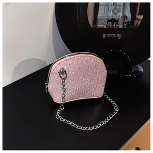 Detail of glittery pink mini shell bag with shiny rhinestones and silver metal chain