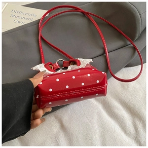 Detailed shot of red polka dot mini bag with lace trim and slim shoulder strap
