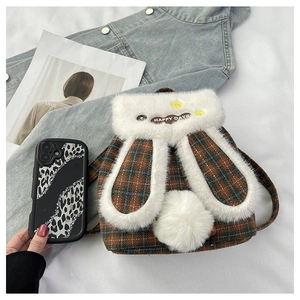 Detail of cute plush bunny backpack with brown blue plaid pattern and Happy Days embroidery