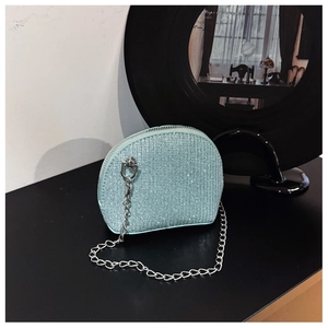 Detail of mint green shell-shaped crossbody bag with sparkling sequins and silver chain