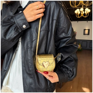Détail de la boucle cœur dorée sur le mini sac bandoulière à texture croco pour enfants