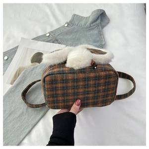 Detail of cute plaid plush bunny bag with white faux fur ears and fluffy ball pompom