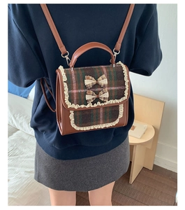 Close-up of plaid children's backpack featuring lace trim and cute decorative bowknots