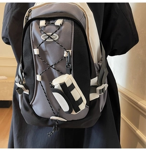 Rückansicht eines grauen Nylon-Rucksacks mit abnehmbarer Mini-Tasche und elastischem Kordelzug