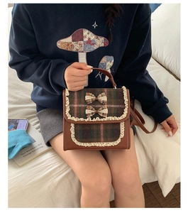 Detail of plaid kids backpack with lace trim and bow accents in vintage academic style