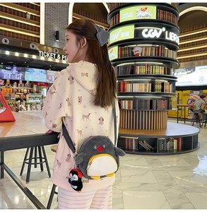 Detailaufnahme der Pinguin-Plüschtasche mit süßem Mini-Pinguin-Anhänger für Damen