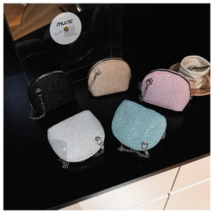Detailed close-up of colorful sequin shell bags with metal chains on a vintage desk
