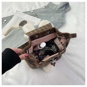 Detail view of the plush rabbit ear bucket bag interior with plaid fabric and drawstring