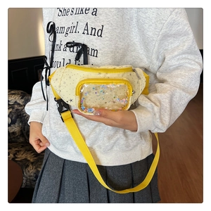 Dettaglio del marsupio giallo per bambini con motivi a stelle e tasca con paillettes