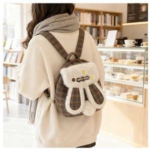 Detail of cute rabbit backpack with brown checkered fabric and white plush ears