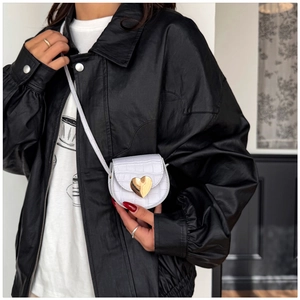 Détail d'un mini sac bandoulière blanc avec fermoir cœur doré et texture crocodile