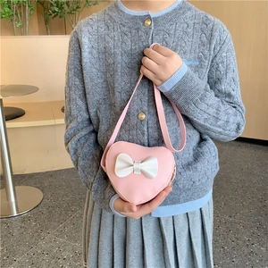 Pink heart-shaped crossbody bag for girls with white 3D bow detail and PU leather finish