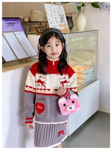 Detail of red heart pocket and cartoon bear embroidery on knitted girl sweater
