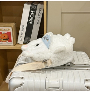 Detail of white fluffy puppy plush crossbody bag with cute blue hat accent on luggage
