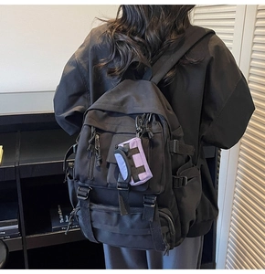Nahaufnahme des schwarzen taktischen Rucksacks mit kontrastierendem lila Schlüsselanhänger