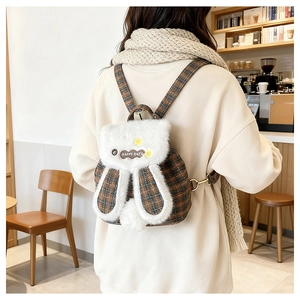 Detail view of a cute plush rabbit plaid backpack with HAPPY DAY patch and fuzzy ears