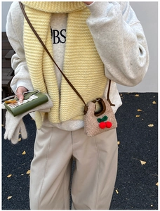 Winter mini cherry plush bag shown with knit scarf and white sweatshirt outfit detail