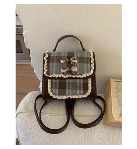 Detail of vintage plaid school backpack with lace trim and cute decorative bows