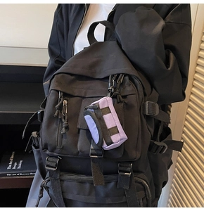 Nahaufnahme eines schwarzen taktischen Rucksacks mit lila Mini-Schlüsseltaschen-Accessoire