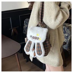 Detail of cute plush bunny backpack with plaid pattern and Happy Days label