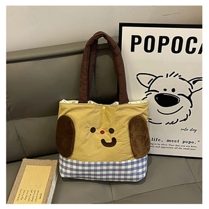 Detail of yellow cartoon dog tote bag with blue plaid fabric and secure button closure