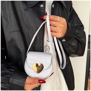Détail du mini sac blanc à texture crocodile avec un fermoir doré en forme de cœur