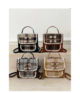 Detail view of plaid mini backpacks with lace trim and bow accents for kids