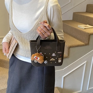 Bolso de mano infantil marrón oscuro con bordados de postres y un tierno colgante de perrito