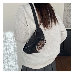 Dettaglio del marsupio nero per bambini con stelle e tasca in PVC con glitter a cuore