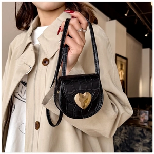 Vue détaillée du mini sac noir à motif crocodile avec son fermoir cœur doré brillant