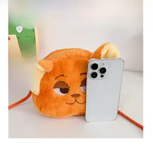 Detail view of the orange plush fox shoulder bag showing compact size compared to a phone