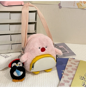 Detailansicht der pinkfarbenen Plüsch-Umhängetasche mit Pinguin-Anhänger und weichem Fell