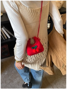 Mini cherry plush shoulder bag for children shown in a warm home lifestyle setting