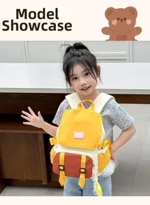 Détail du sac à dos jaune pour enfants avec poche marron et breloque fleurie douce