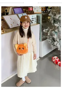 Close-up of orange plush fox bag with 3D ears and embroidery on a child model