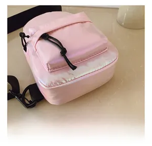 Dettaglio ravvicinato del tessuto olografico rosa e delle cuciture sulla borsa da petto bimbo