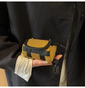 Nahaufnahme einer taktischen Mini-Schlüsseltasche in Senfgelb mit D-Ring-Haken
