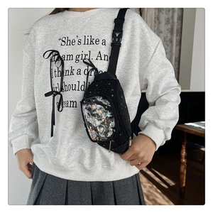 Dettaglio del marsupio nero per bambini con motivo a stelle e tasca con paillettes