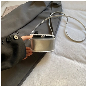 Détail du mini sac argenté métallisé avec bordure en dentelle blanche et bandoulière