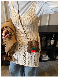 Detail of teddy plush mini crossbody bag with cherry charms on crochet dress