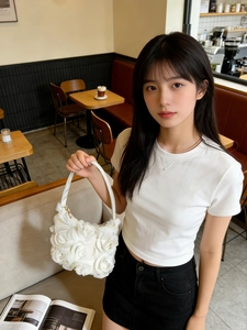 Détail du sac de soirée blanc à fleurs 3D avec pétales en tissu élégants et sangle