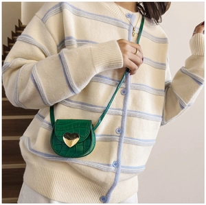 Détail de texture crocodile vert et boucle en métal en forme de cœur sur le mini sac